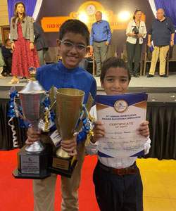 raphael and mikael holding certificates and trophies